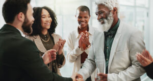 Group of people applauding and shaking hands in celebration of Black History Month